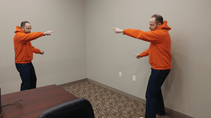 A person pointing at an exact copy of themselves